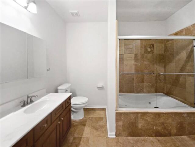 full bathroom featuring shower / bath combination with glass door, vanity, and toilet