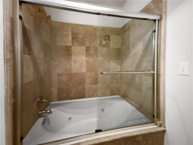 bathroom featuring combined bath / shower with glass door