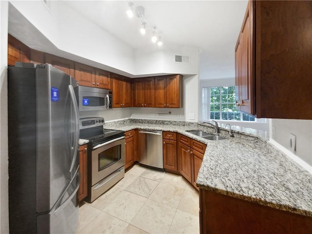 200 Renaissance Pkwy NE Unit 302, Atlanta, GA 30308 - kitchen featuring visible vents, light stone counters, brown cabinets, appliances with stainless steel finishes, and a sink