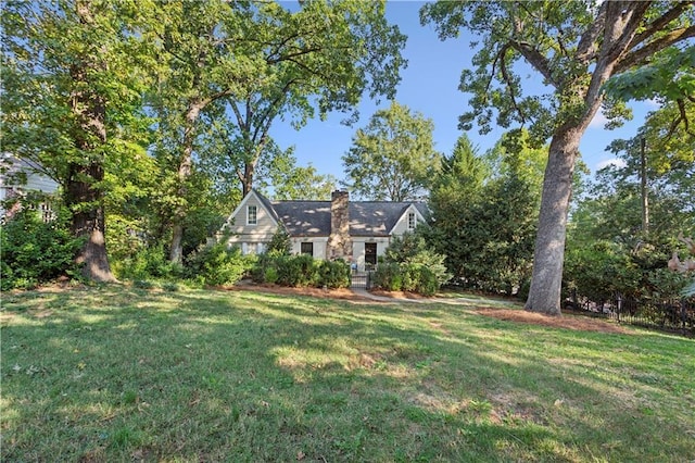 view of front facade featuring a chimney and a front yard