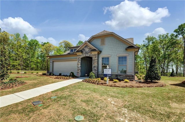 view of front facade with stone siding, a front lawn, an attached garage, and driveway