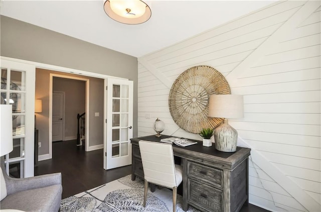 home office with french doors, wood finished floors, and wooden walls