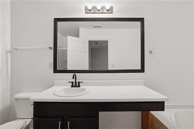 bathroom with vanity, toilet, and a bathtub
