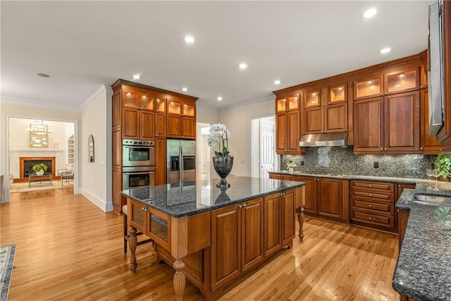 1655 Arrowhead Trl NE, Atlanta, GA 30345 - kitchen with appliances with stainless steel finishes, under cabinet range hood, light wood finished floors, ornamental molding, and decorative backsplash