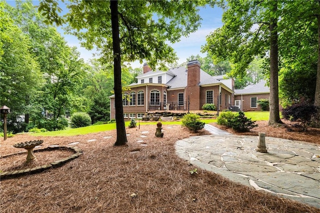 1655 Arrowhead Trl NE, Atlanta, GA 30345 - back of house with a chimney, a patio area, a deck, brick siding, and a yard