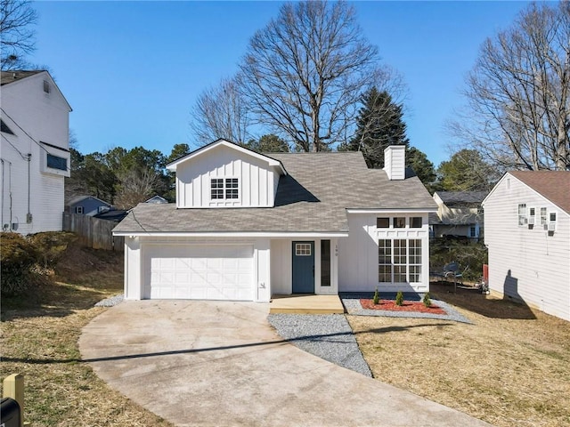 view of front of house with a chimney, concrete driveway, board and batten siding, a front yard, and a garage