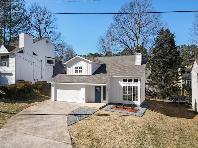 view of front of home featuring driveway, a chimney, an attached garage, a front lawn, and board and batten siding