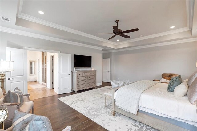 bedroom featuring ornamental molding, hardwood / wood-style floors, ceiling fan, and a raised ceiling