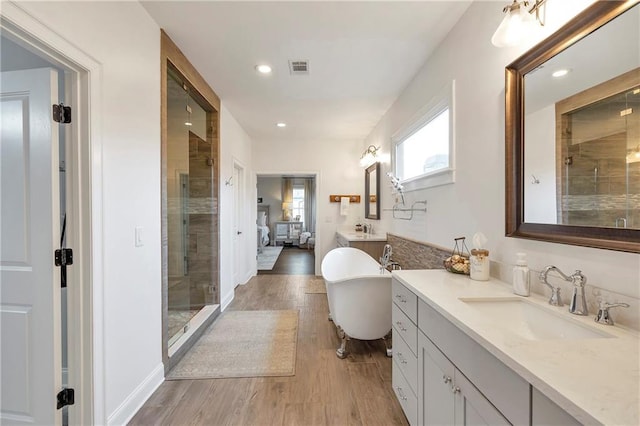 bathroom featuring hardwood / wood-style floors, independent shower and bath, and vanity