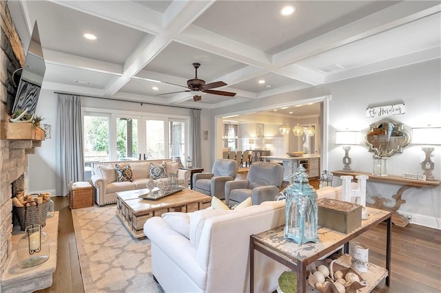 living room featuring coffered ceiling, a fireplace, ceiling fan, beam ceiling, and light wood-type flooring