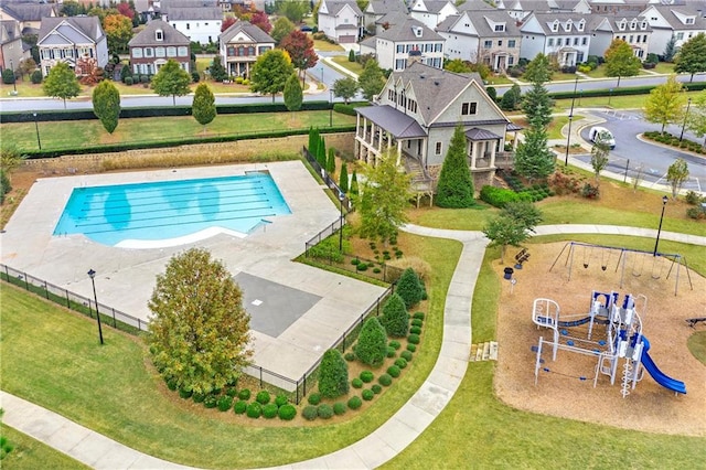 view of swimming pool with a playground and a lawn