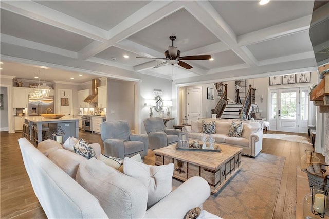 living room with light hardwood / wood-style floors, coffered ceiling, ornamental molding, beamed ceiling, and ceiling fan