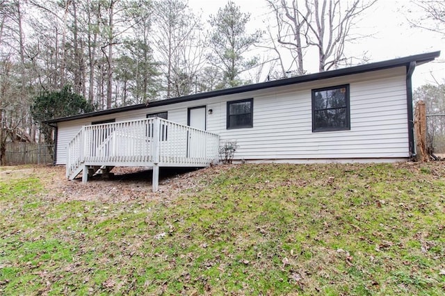 view of front of property featuring a front lawn, fence, and a wooden deck