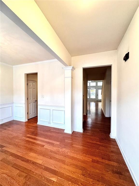 hall with ornate columns, dark wood-type flooring, and ornamental molding