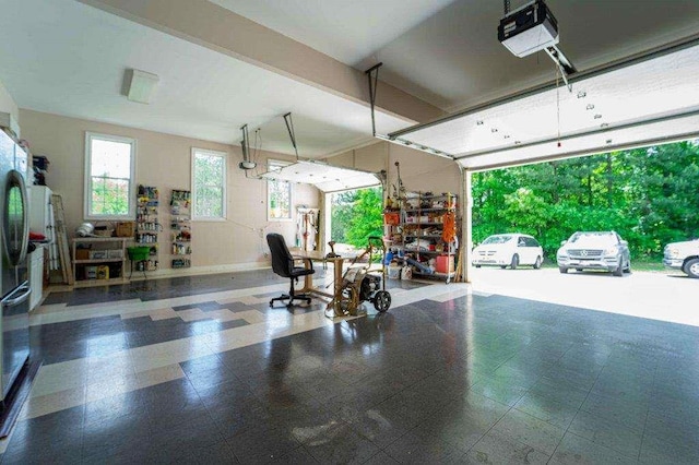 garage with stainless steel fridge and a garage door opener