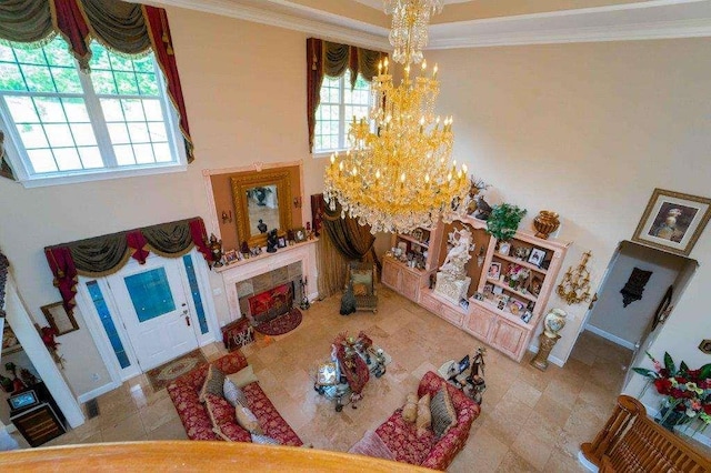 interior space with a high ceiling, tile patterned flooring, crown molding, and an inviting chandelier