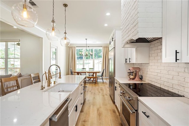 kitchen featuring high quality appliances, a healthy amount of sunlight, decorative light fixtures, and white cabinets