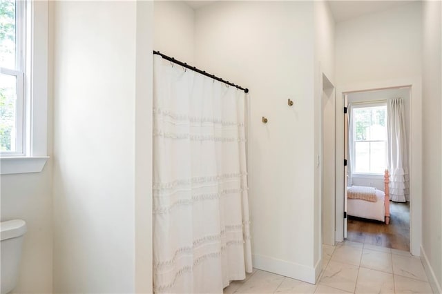 bathroom with toilet, hardwood / wood-style flooring, and curtained shower