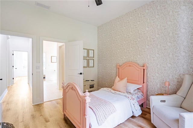 bedroom featuring light hardwood / wood-style floors, high vaulted ceiling, and ceiling fan