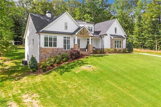 view of front of house with a porch, a front lawn, and central AC