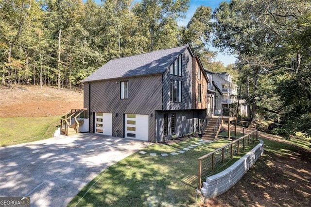 view of side of home featuring a garage and a lawn