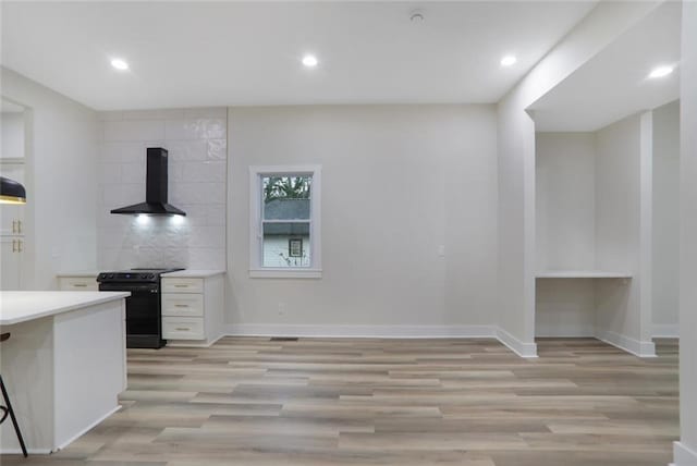 kitchen featuring baseboards, extractor fan, light countertops, electric range, and white cabinetry