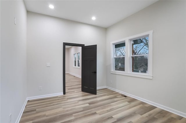 spare room featuring recessed lighting, baseboards, and light wood-style floors