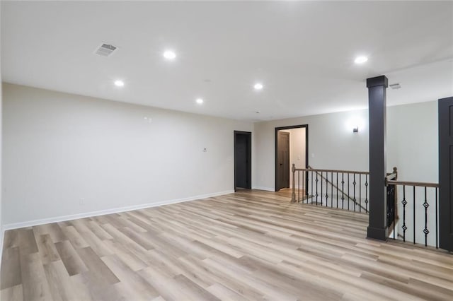 empty room featuring light wood-type flooring, visible vents, baseboards, and recessed lighting