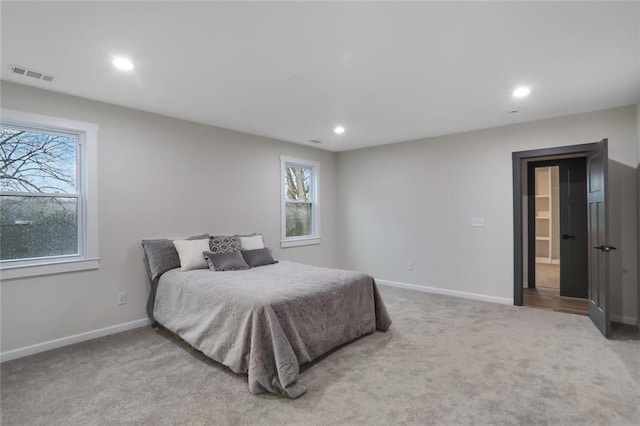 bedroom featuring recessed lighting, visible vents, light colored carpet, and baseboards