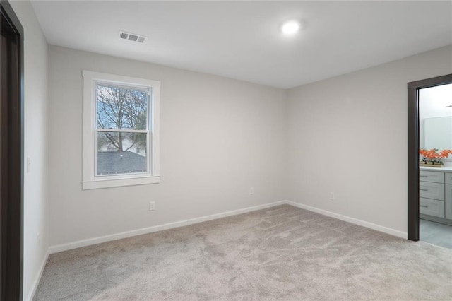 unfurnished bedroom featuring light carpet, visible vents, and baseboards