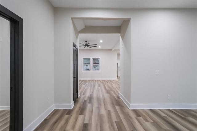 corridor featuring recessed lighting, baseboards, and wood finished floors