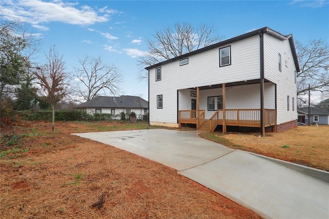 rear view of house with crawl space, covered porch, and a lawn