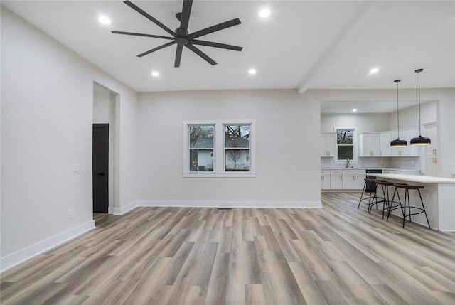 unfurnished living room featuring recessed lighting, baseboards, and light wood-style flooring