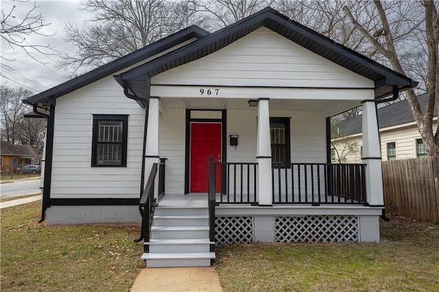 bungalow with a front yard, covered porch, and crawl space