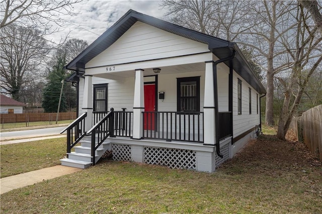 view of front of house featuring a porch, crawl space, a front lawn, and fence