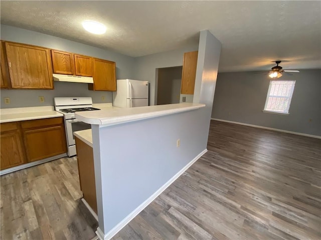 kitchen featuring stainless steel fridge, white gas range oven, a textured ceiling, ceiling fan, and wood-type flooring