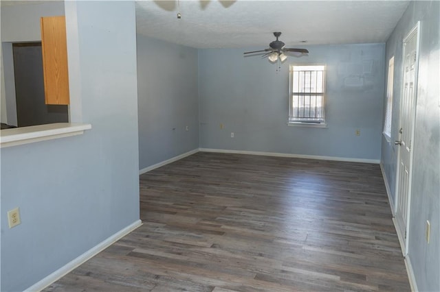 spare room featuring dark wood-type flooring and ceiling fan