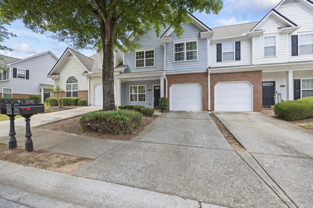 townhome / multi-family property featuring brick siding, driveway, and a garage