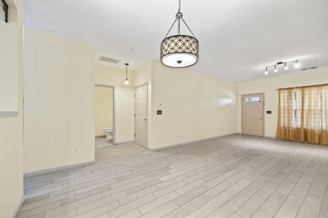 empty room with baseboards, visible vents, and light wood-style flooring