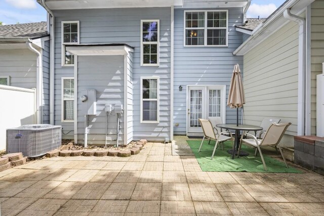 rear view of property with outdoor dining space, a patio area, fence, and cooling unit
