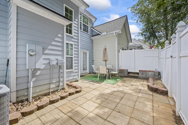 view of patio with a fenced backyard, outdoor dining area, and central AC
