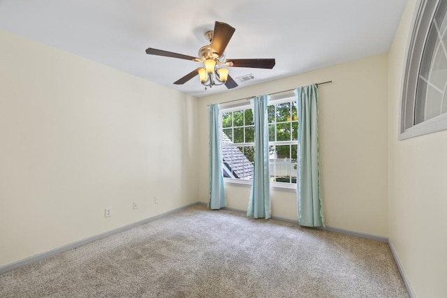empty room featuring carpet floors, ceiling fan, baseboards, and visible vents