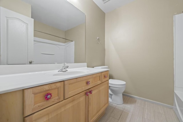bathroom featuring toilet, baseboards, tub / shower combination, and vanity