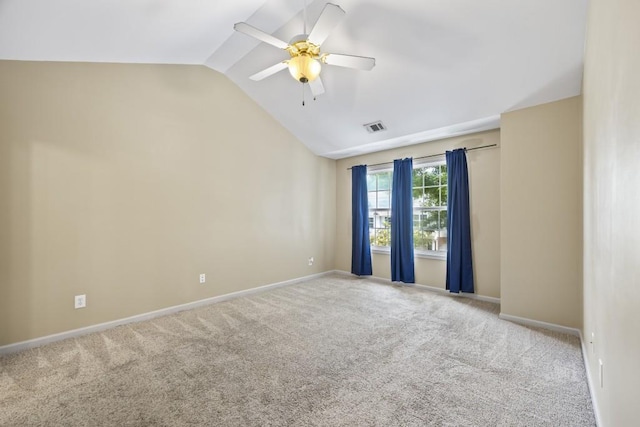spare room with visible vents, baseboards, carpet floors, and vaulted ceiling