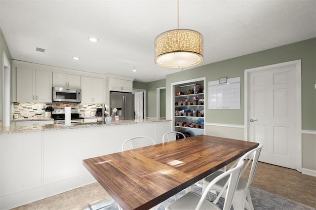 dining area with built in shelves and light tile patterned flooring