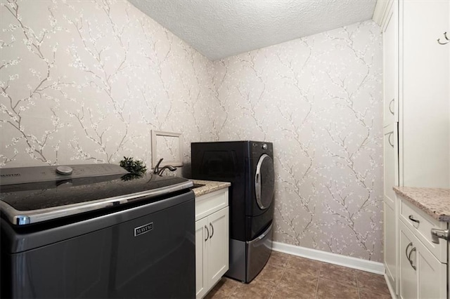 laundry room featuring washer / dryer, a textured ceiling, cabinets, and sink