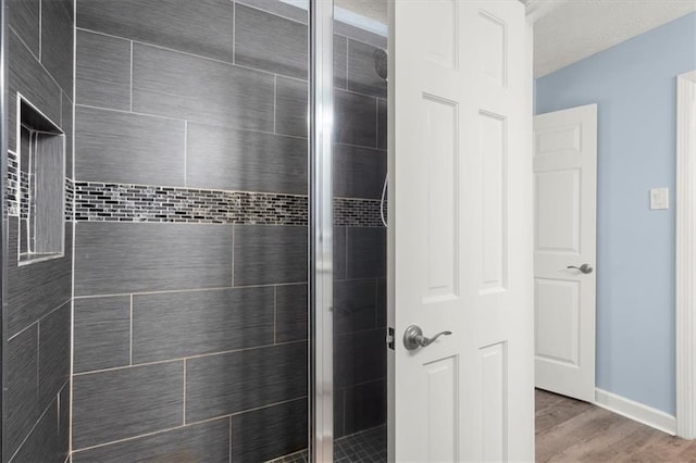 bathroom with hardwood / wood-style floors and a shower with shower door