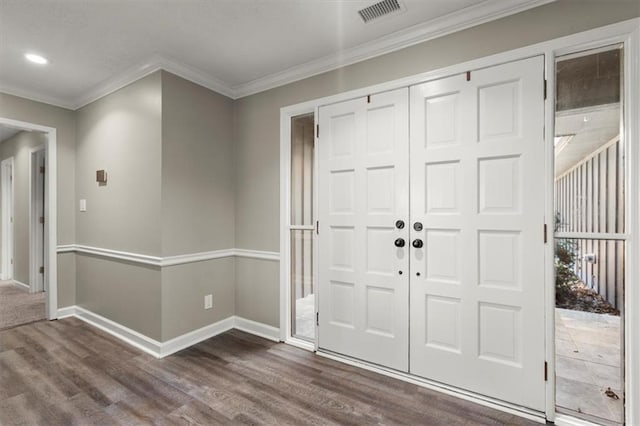 foyer entrance featuring dark wood-type flooring and crown molding