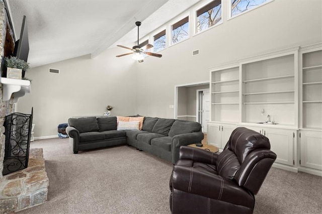 carpeted living room featuring beam ceiling, ceiling fan, high vaulted ceiling, and a fireplace