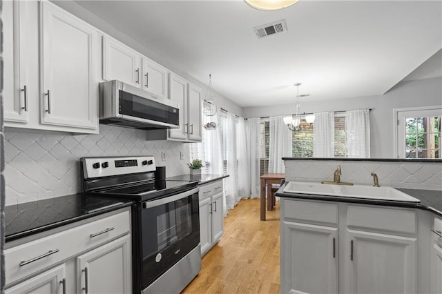 kitchen with visible vents, a chandelier, backsplash, dark countertops, and stainless steel appliances